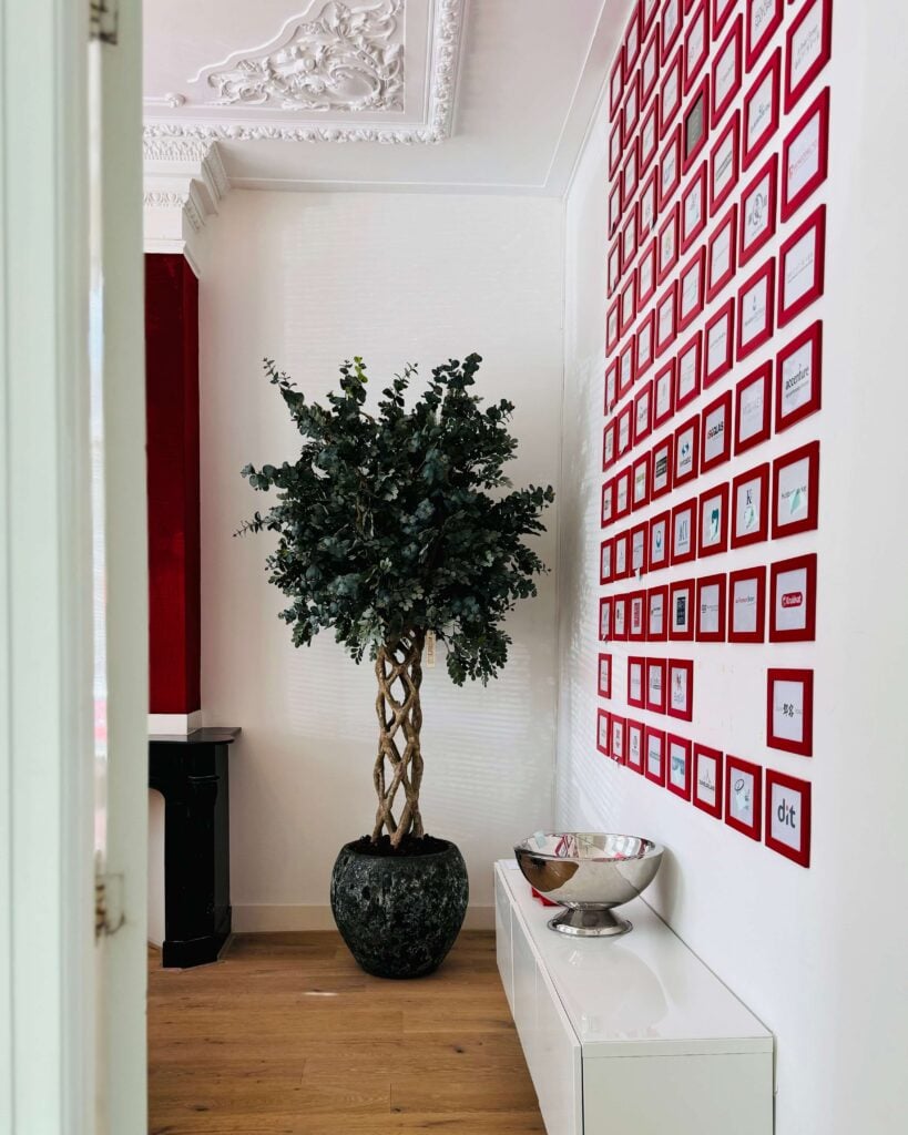 Eucalyptus kunstboom op een gedraaide echte stam, geplaatst in een zeegroene Lava pot in een moderne hal. STYLERZ24