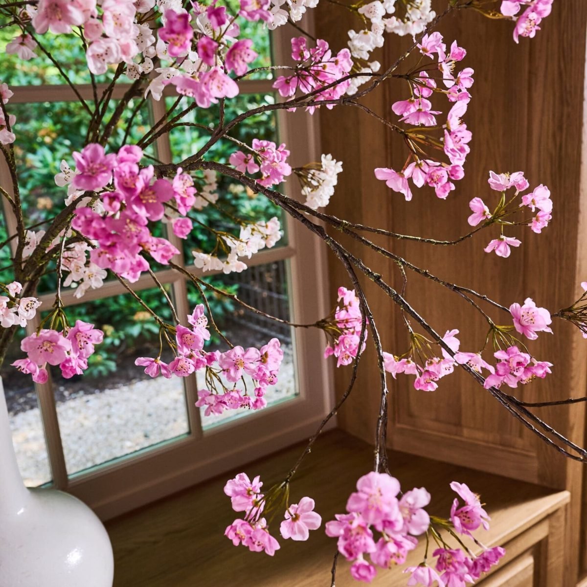 Roze zijden bloesemtakken in een sfeervolle binnenruimte, onderdeel van de tijdloze collectie van STYLERZ24